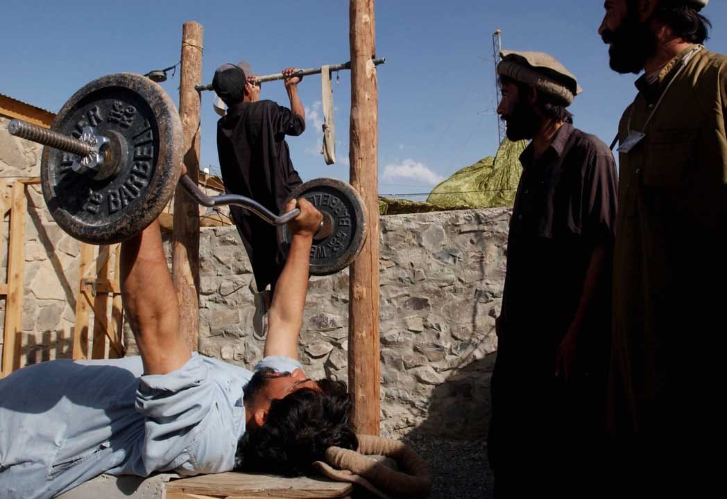  2002年9月15日，阿富汗，几名阿富汗人在室外的建身设施建身。摄：Chris Hondros/Getty