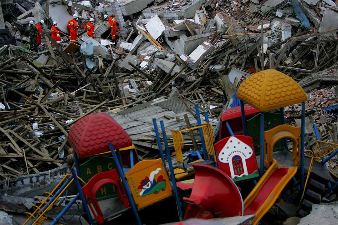 2008年5月14日，中國士兵在綿陽市一間倒塌幼稚園遺址中搜救生還兒童。