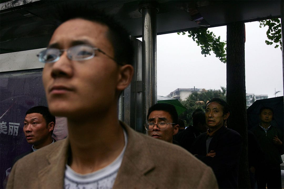 2008年5月13日，四川都江堰市居民旁觀救援人員在瓦礫中搜救生還者。