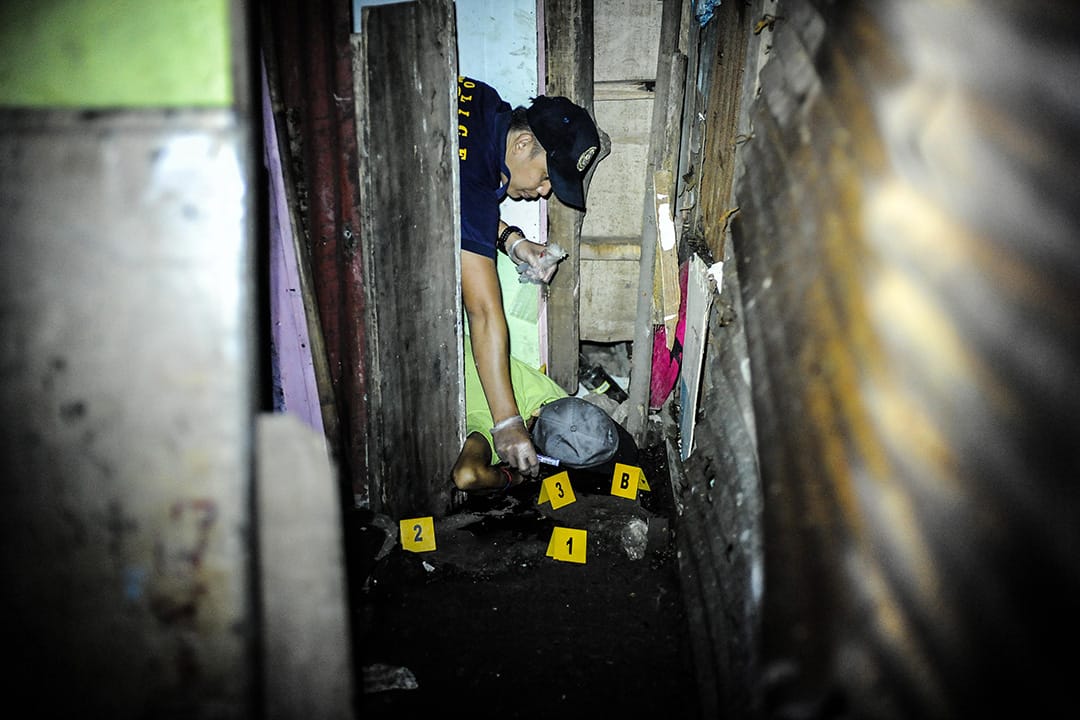 2016年6月25日,菲律賓馬尼拉,三名毒販被槍殺後,法醫檢查其中一具屍體。