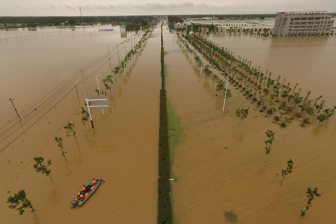 中國安徽,救援人員乘船檢查被洪水淹沒的道路。