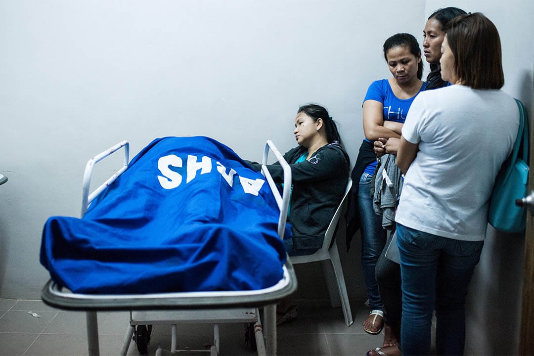 2016年8月20日,菲律賓馬尼拉,家屬站在一個警員的屍體旁。