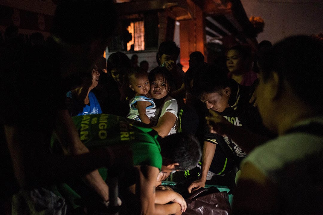 2016年8月17日,菲律賓馬尼拉,家屬圍著一個被疑為毒販者的屍體。