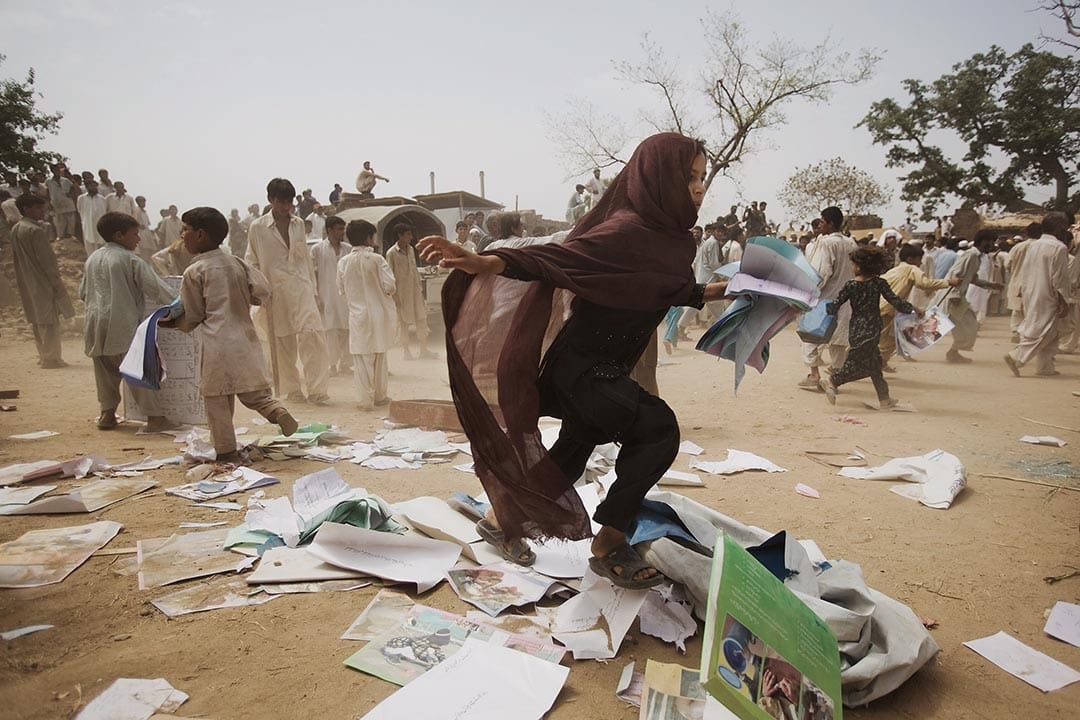 巴基斯坦,暴徒洗劫难民营后,一位流离失所的女孩在逃跑。