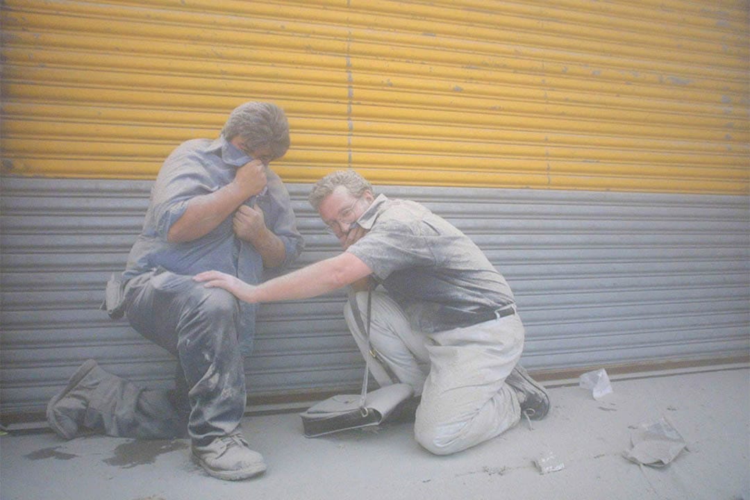 2001年9月11日,世贸中心倒塌后,两名市民在浓烟中掩著面。