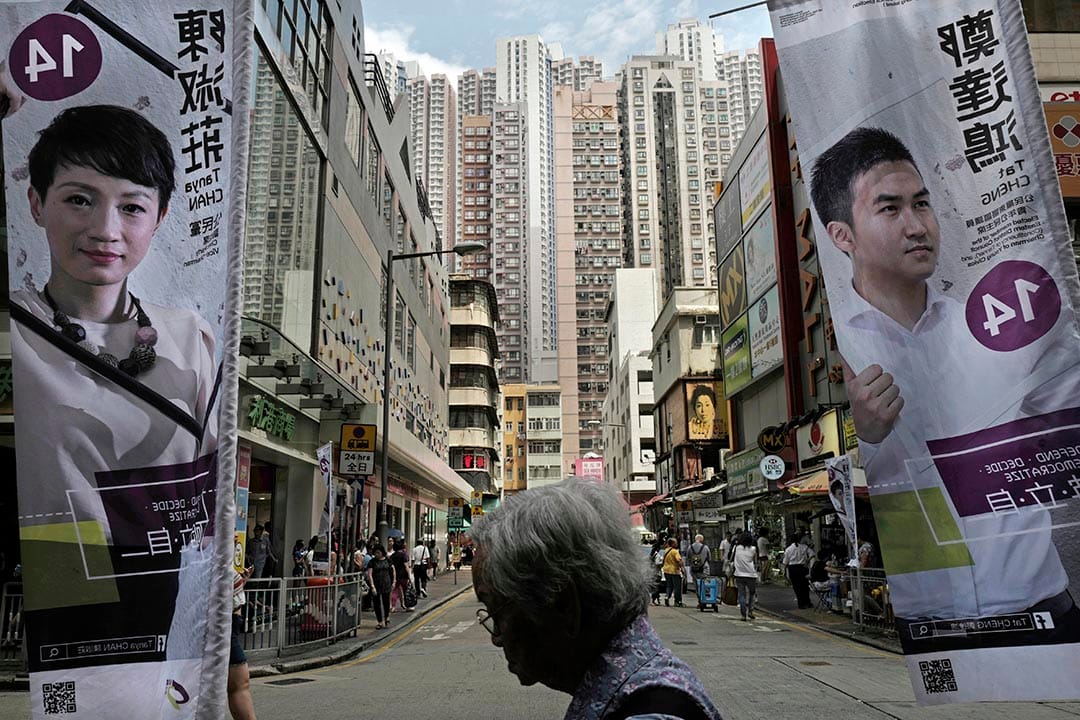 一位女士走過公民黨的宣傳直幡。