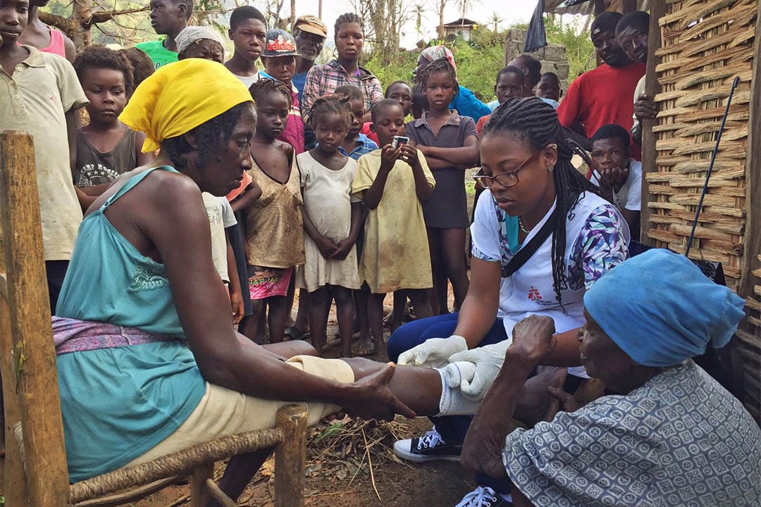 一名來自海地的無國界醫生護士乘坐直升機到皮茫港北面山區的一條村落為村民治理傷口。