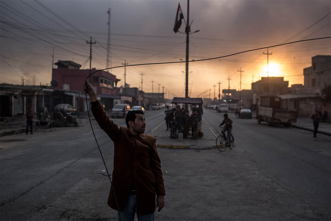 2016年11月9日，伊拉克盖亚拉，一个男人手抓住电缆。