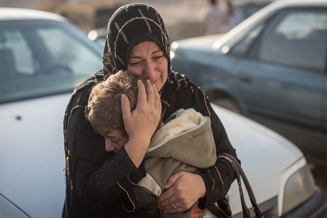 2016年11月7日，伊拉克高吉亚利，一个女人回到家乡后紧抱着分隔两年多的孩子。