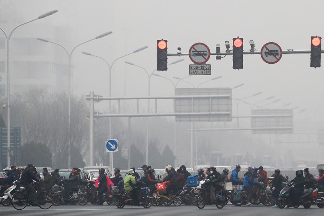 中國北京,市民騎單車和電動車橫過馬路。
