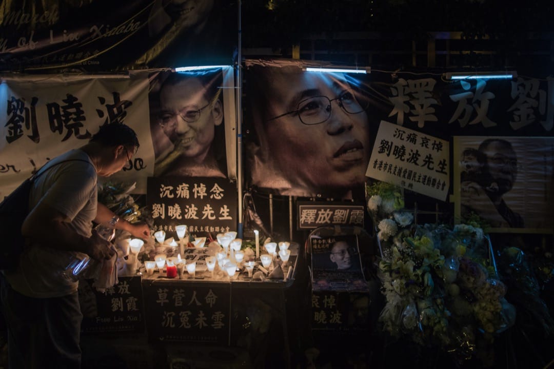 游行人士到达中联办后,放下鲜花和蜡烛后离开。