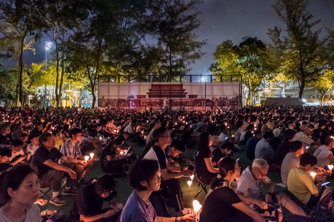 2017年6月4日,香港维园举行六四晚会。参与者在天安门广场的大横幅旁,手持烛台,悼念天安门事件中的死难者。