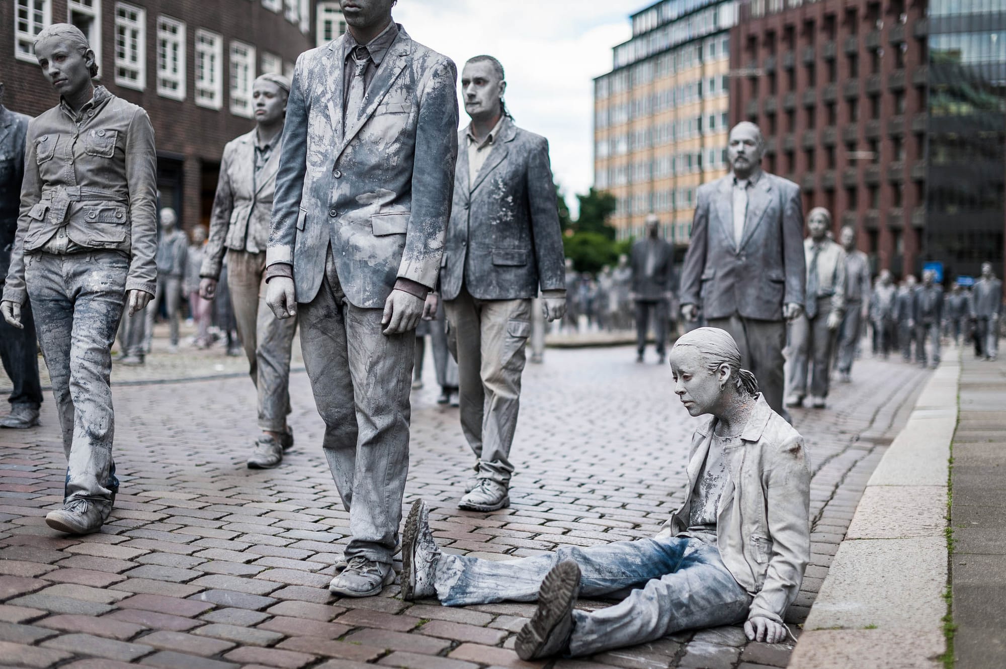 2017年7月5日，「1000 Figures」的行為藝術表演中，這位表演者頹喪無力地坐在路邊，目光空洞。