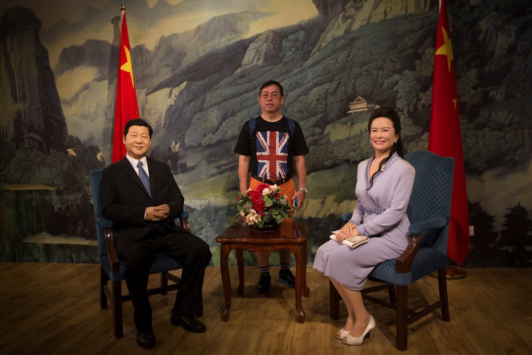 2017年7月1日,香港回归20年之际,香港杜莎夫人蜡像馆中,一位身穿印有英国国旗的T恤的市民和国家主席习近平及其夫人彭丽媛的蜡像合影。