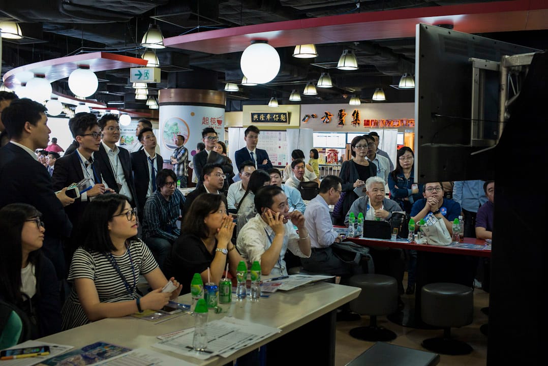 2017年5月31日,一群地产经纪正在注视前方的电视,等待著搅珠结果。