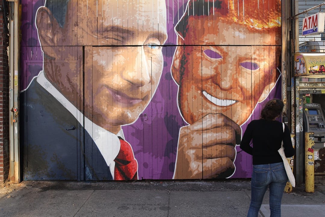 2017年2月25日，在美国纽约市布鲁克林区，一名途人行经一个画上了俄罗斯总统普京拿著特朗普面具的店铺门口。