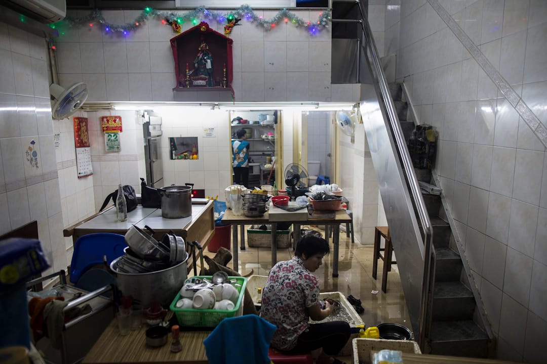 澳門遭颱風「天鴿」吹襲，多區出現嚴重水浸，一間店舖的居民正在清理積水及執拾。