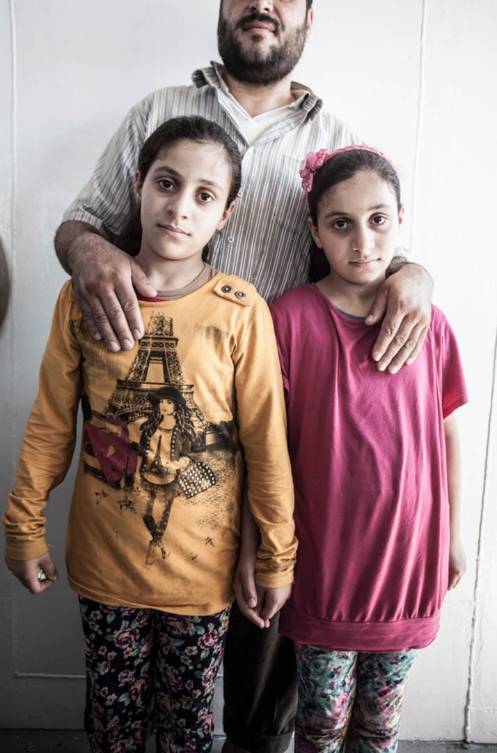 9岁的双胞胎 Aziza 和 Afra,和因为害怕巴沙尔政权逼害而不想被拍摄的爸爸。