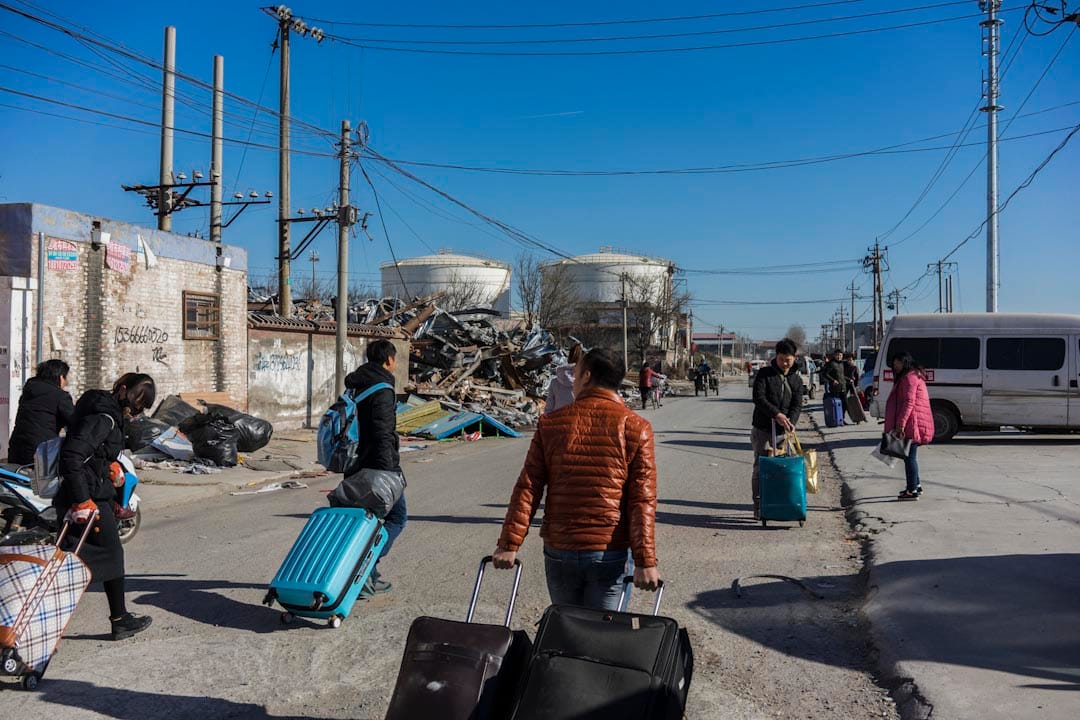 2017年11月26日上午，一群來自湖北的外來租戶拖着行李箱離開新建村。