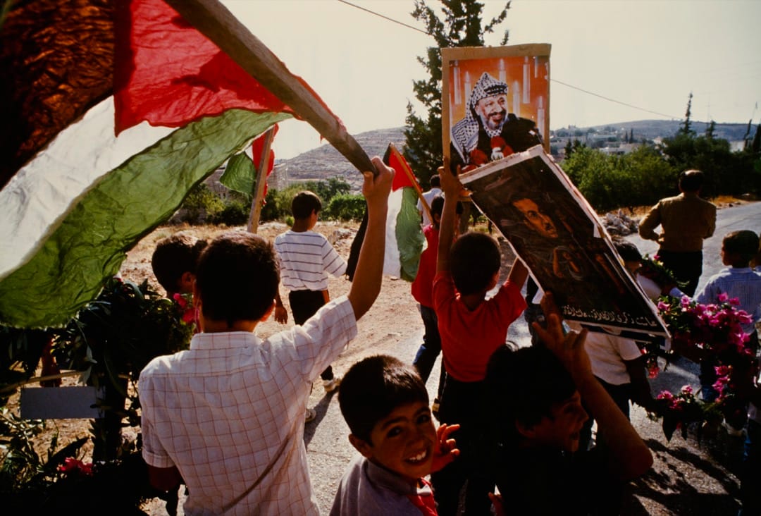 1989年6月，在巴勒斯坦被佔的土地上，巴勒斯坦兒童舉標語和旗幟表示支持巴解組織領導人阿拉法特。
