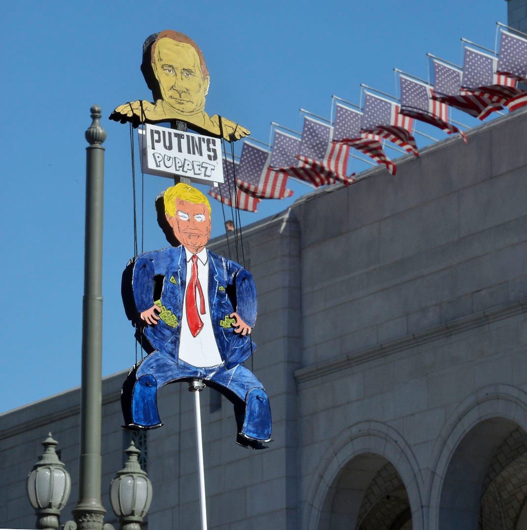 洛杉矶，约350,000人参与2018年度女性大游行，将对美国总统特朗普的愤怒化成力量唤起民众对女性议题的关注。其中有参与者自制纸牌讽刺特朗普是俄罗斯总理普京的傀儡。