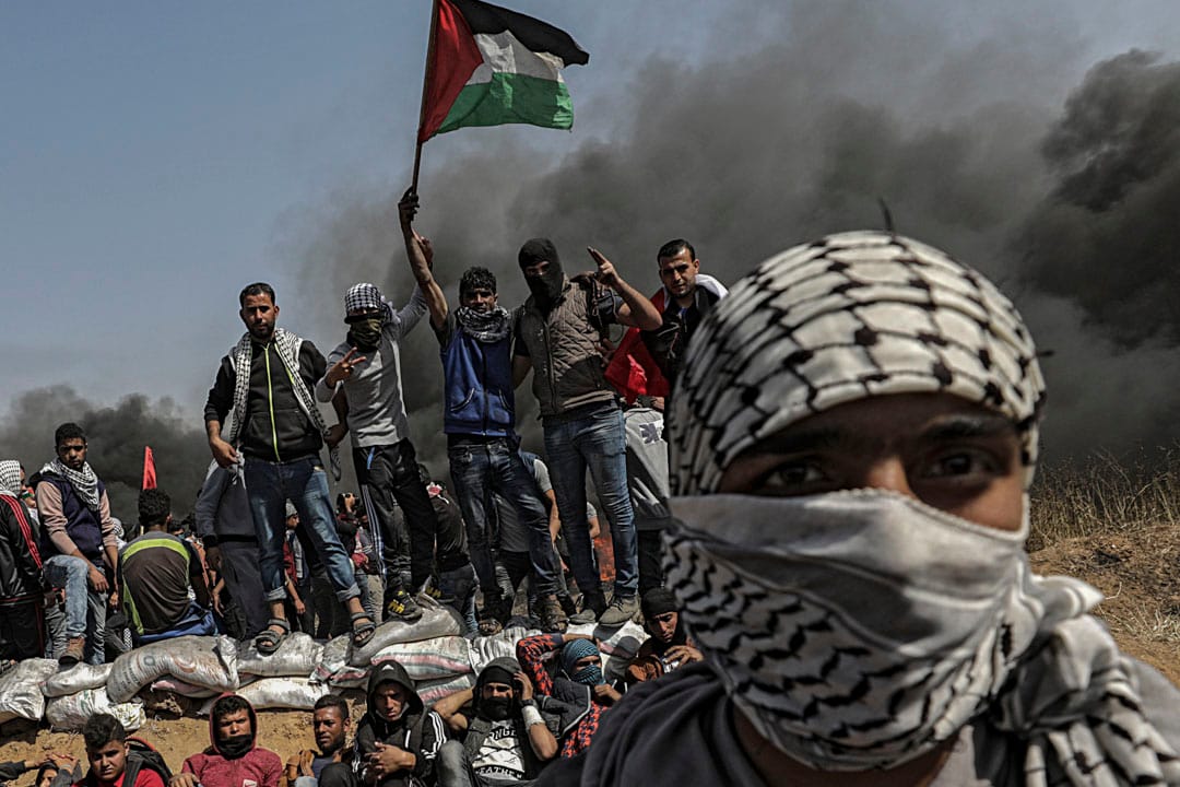 示威者在衝突期間高舉巴勒斯坦國旗。