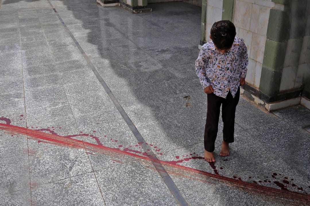 2018年5月14日,也门城市塔伊兹,一名男孩凝望着地上的血痕。较早前市内最大的清真寺的领袖 Mohammed Al-Zabhani被刺杀,在地上留下血迹。
