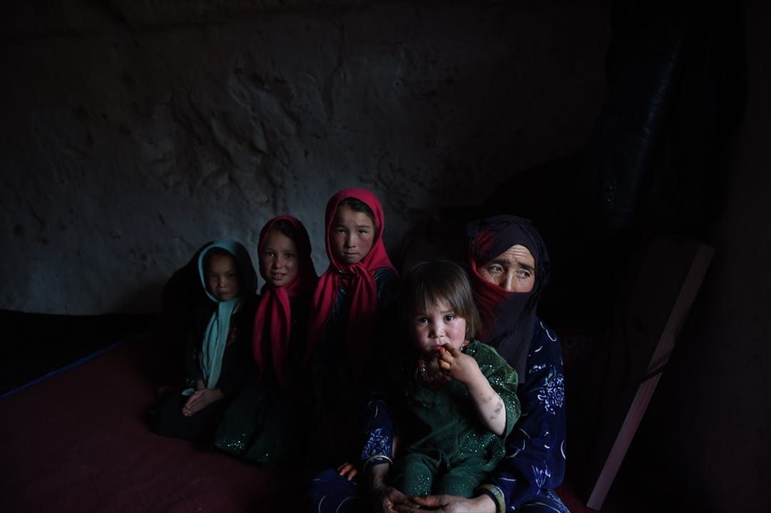 2015年6月19日，喀布尔200公里以西北的巴米扬市，一名哈扎拉女人和她的孩子在她们的洞穴里坐着。巴米扬谷的数百个人造洞穴里住进了不少贫困的无家者。