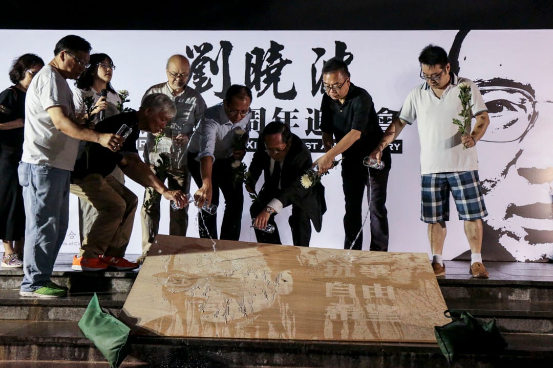支聯會代表向印有劉曉波肖像,以及抗爭、自由、希望等字眼的畫板灑水,寓意祭奠劉曉波。