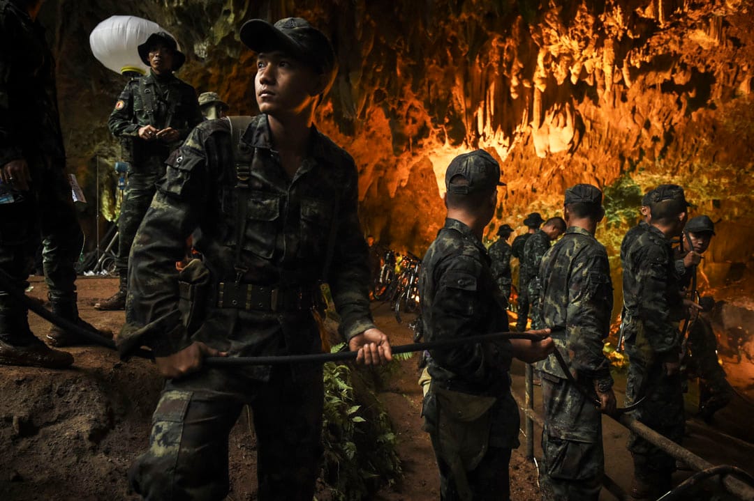 6月26日，泰国军队士兵正把电线拉进洞穴内，方便搜救工作进行。