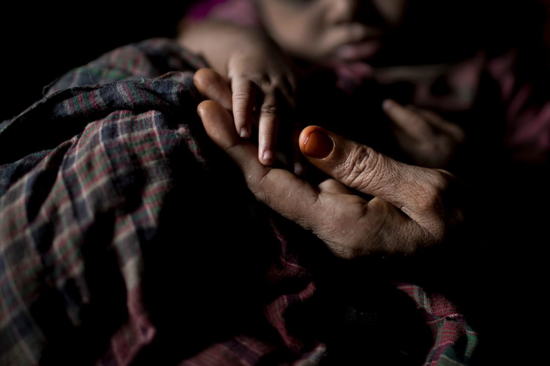 住在Balukhali难民营的“S”手里执著她刚诞下不久的男婴的小手。