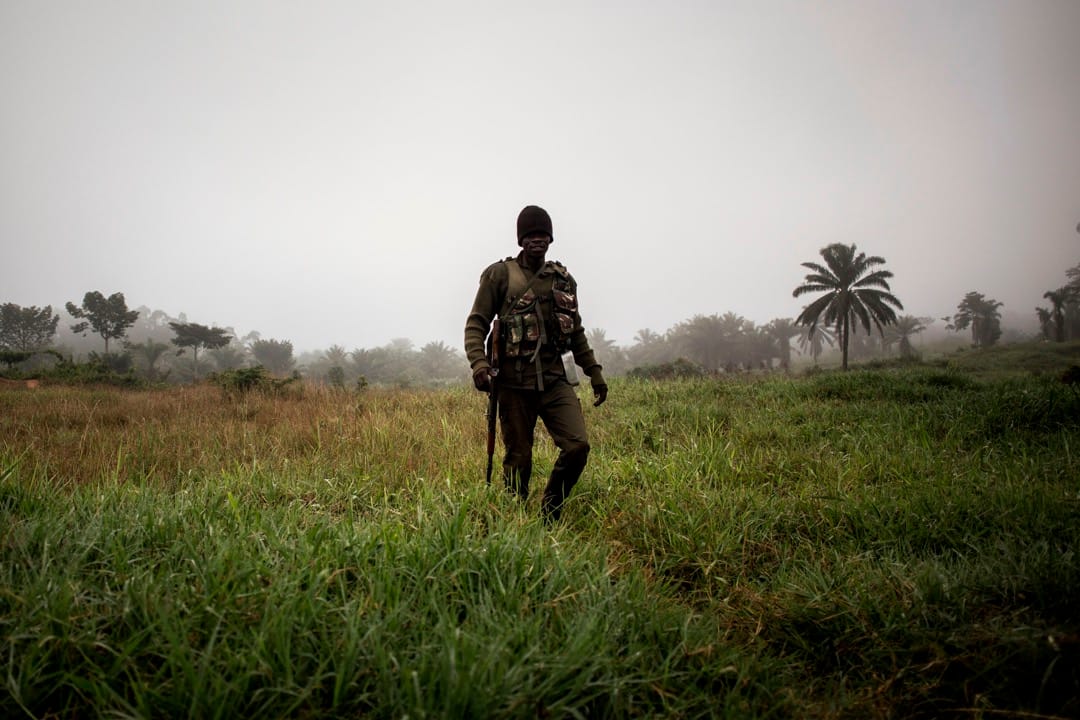 一名政府軍士兵在通宵看守哨站後於清晨時分步行回到基地。