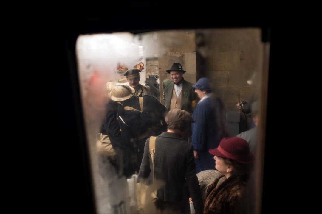 車窗鑲上一層薄薄的水蒸汽,而從窗內看到一班乘客在月台候車。