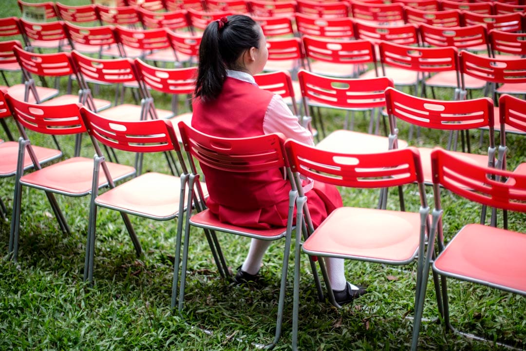西区贺国庆嘉年华开始前,一名学生在观众席观看预演。