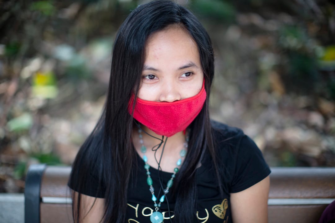 西区贺国庆嘉年华举行的附近,一位女士戴上红色口罩。