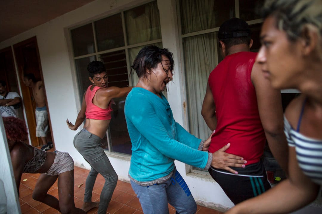 來自中美洲的LGBT移民在當地一家荒廢的旅館外休息，互相打趣跳舞。