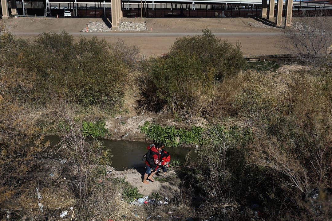 墨西哥邊境城市華雷斯城，一名來自危地馬拉的移民，手抱著孩子預備越過美墨邊境的一段格蘭德河，抵達美國領土後尋求庇護。