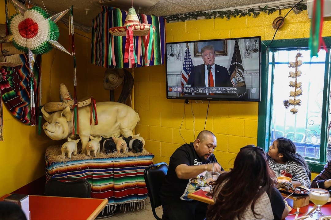 美國德州，Carlos Luna與女兒Dareyna Luna及其家庭在埃爾帕索市的一家墨西哥餐廳裏進餐，電視上播放著美國總統特朗普發表講話的片段。