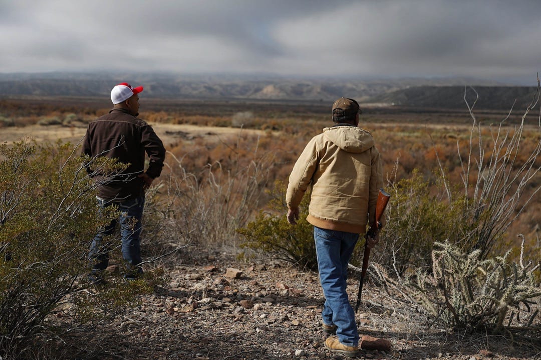 美國德州，Adan Madrid 父子在他們位於坎德拉里亞市的馬場遠觀美墨邊境。