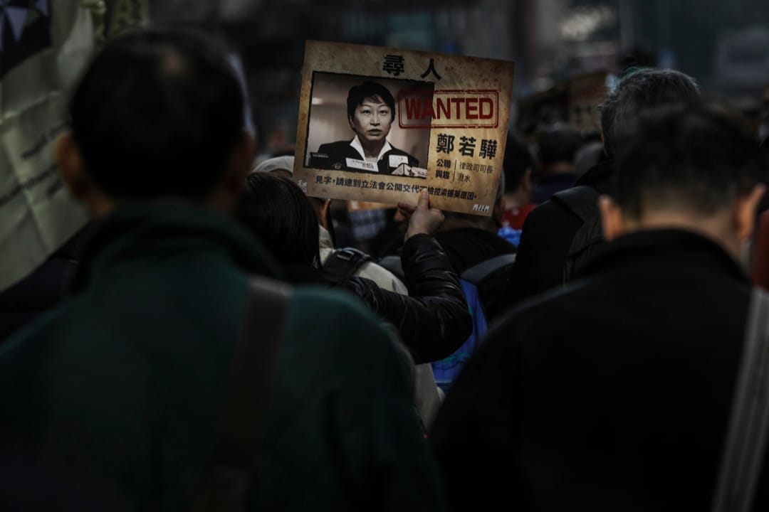 有参与游行的市民举著抗议郑若骅的标语,要求其就捡控前特首梁振英及住宅僭建事宜作出交代。