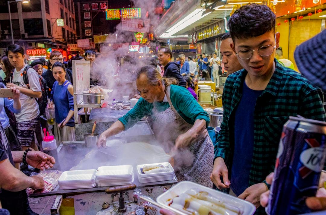 大年初二,旺角变成夜市,小贩卖肠粉。