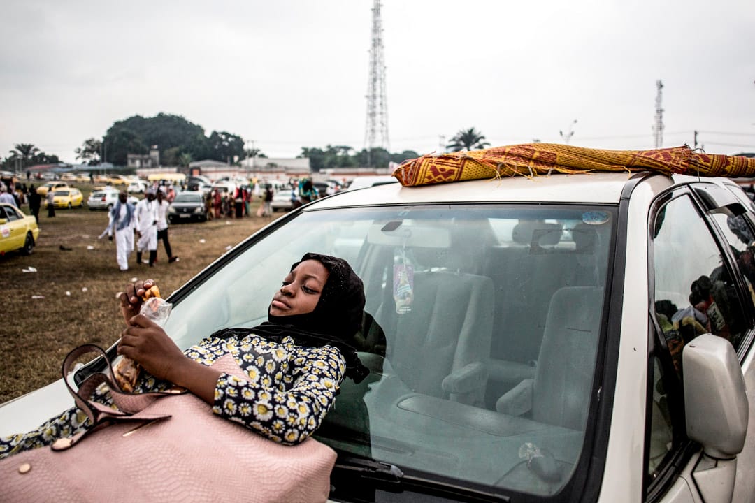 2019年6月4日,刚果烈士体育场外,集体祈祷后,年轻的穆斯林女人在汽车旁等待庆祝开斋节。