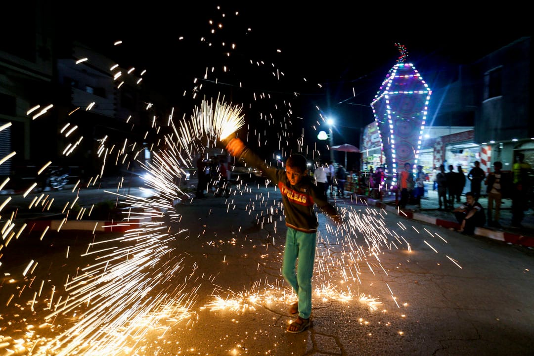 2020年4月22日,加沙地帶南部,一名巴勒斯坦男孩在齋戒月前慶祝活動時揮舞著自製的煙火。