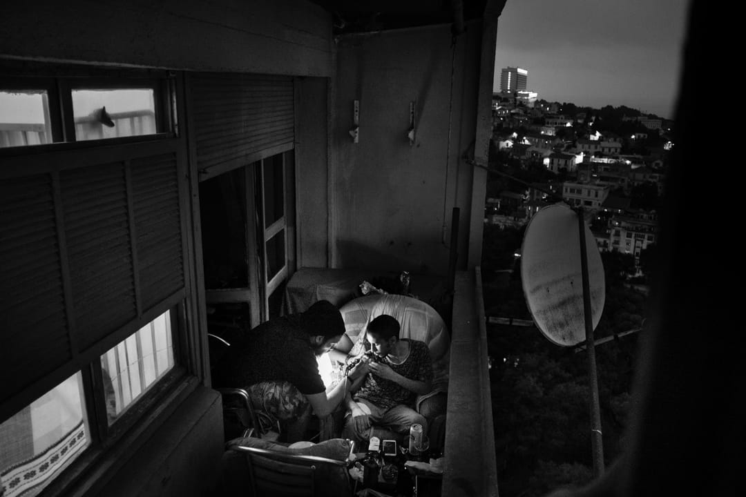 2016年8月26日,阿爾及利亞首都阿爾及爾,一名男子正在陽台上紋身。在伊斯蘭教某些教義詮釋下,紋身是被禁止的,亦不被阿爾及利亞的主流社會接受。