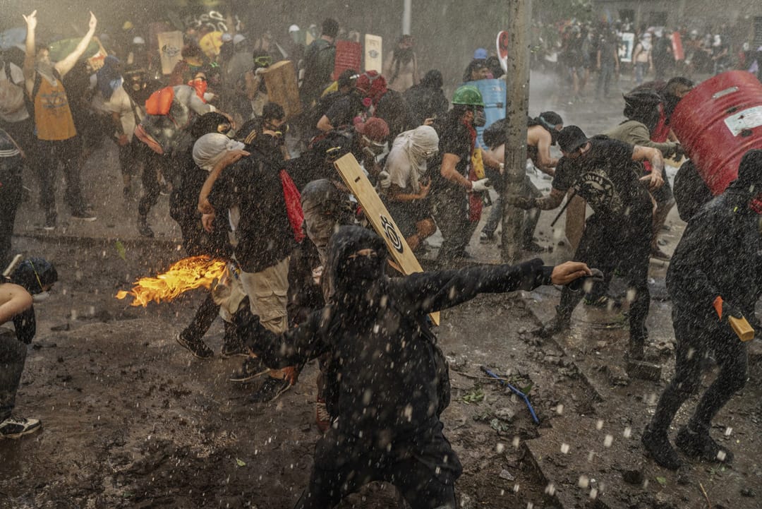 2019年12月13日,智利聖地亞哥的反政府示威者正在向警察投擲氣油彈。示威因為當地鐵路加價而引發,後來演變成要求大規模政府重整和經濟改革,控訴智利的貧富懸殊問題。