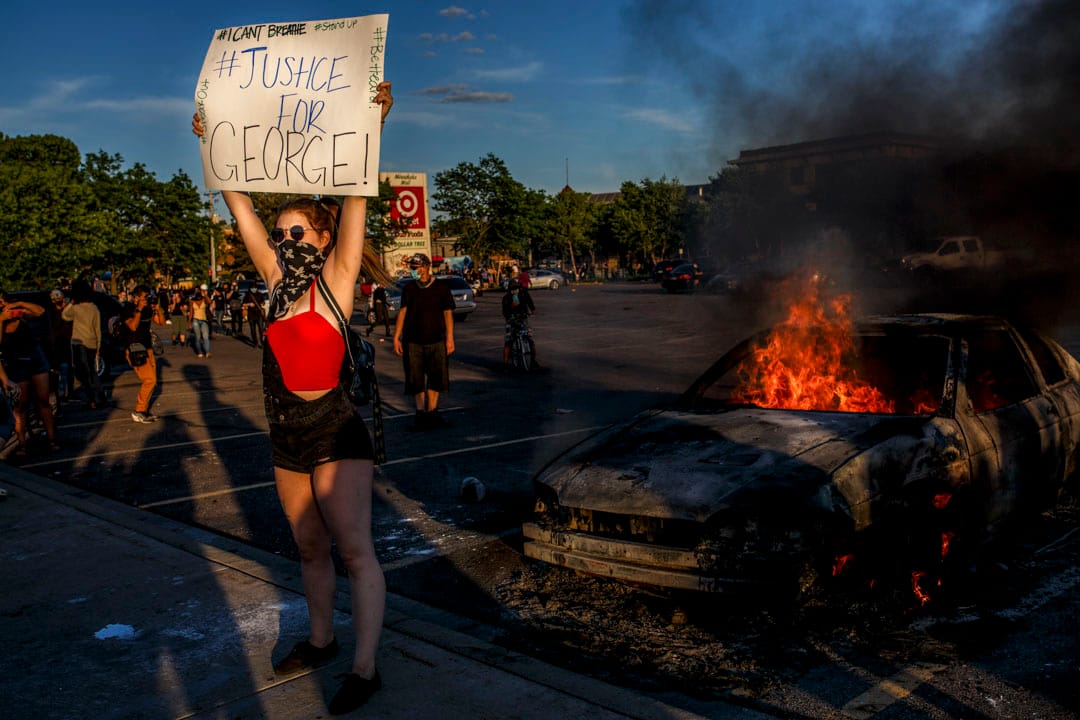2020年5月28日美國明尼蘇達州阿波利斯市，示威者於商店外示威者舉起「Justice for George」的牌子。