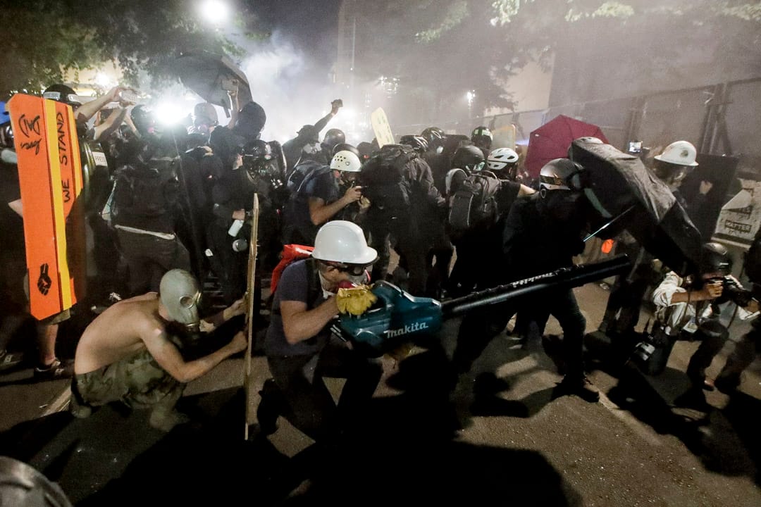 2020年7月29日，波特蘭示威者用傘、木板、吹風機等應對防暴警察發射的催淚彈。