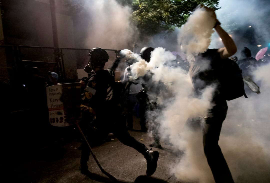 2020年7月29日，波特蘭一場遊行中，示威者將催淚彈罐拾起向對方扔回。