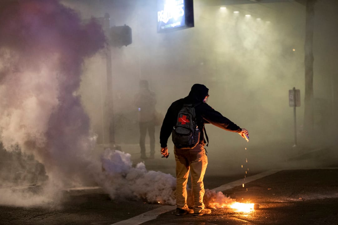 2020年7月29日，波特蘭一場抗議中，一名醫療志願隊人員在催淚彈上倒水。