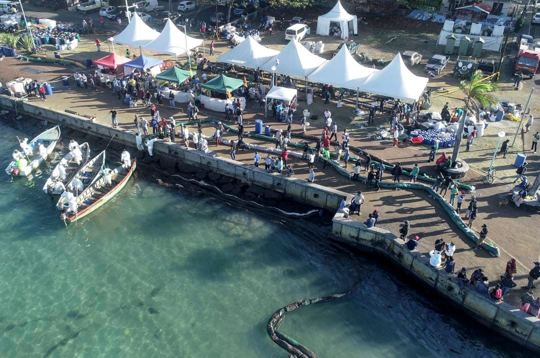 義工在「若潮號」擱淺的岸邊準備臨時浮標，阻止油污擴散。